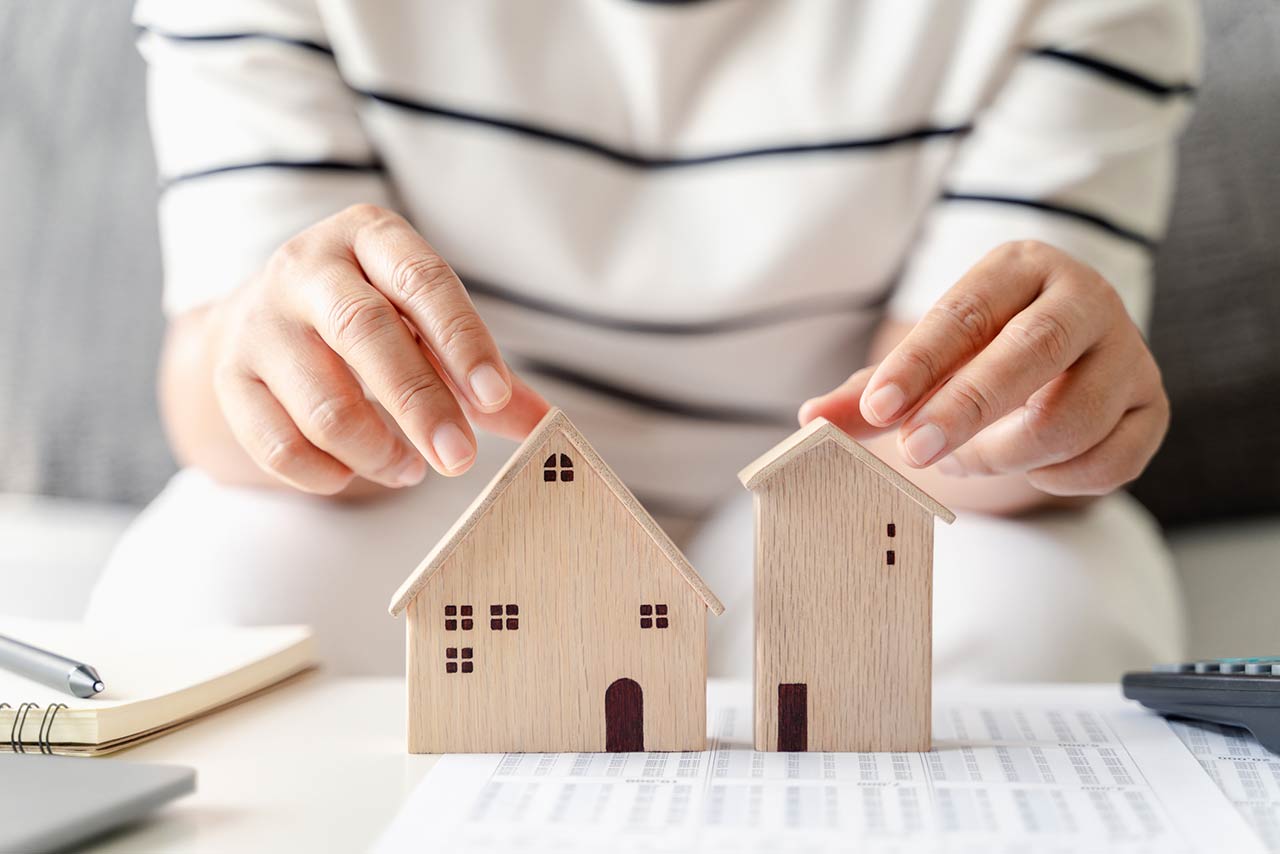 woman is deciding to choose house with Small Wooden House Model